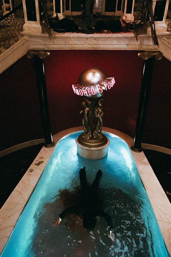 Capture d'écran du film Scarface. Tony Montana mort, flottant dans sa piscine.